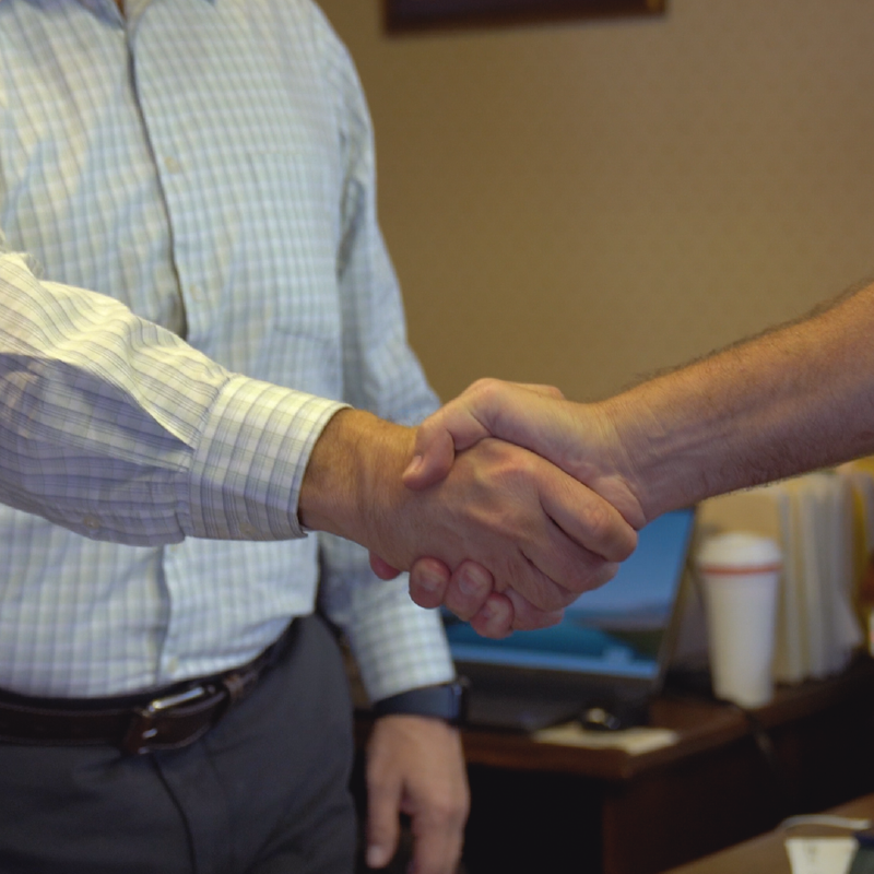 Close-up of two people shaking hands, symbolizing a successful business agreement, partnership, or collaboration in a professional setting.