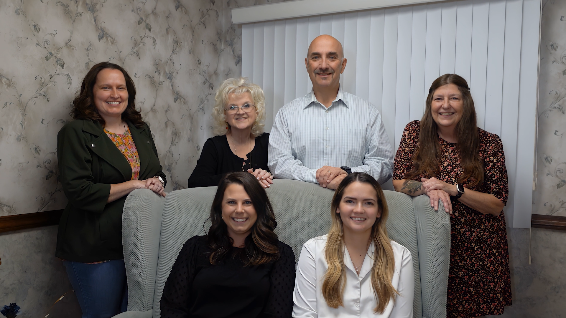 Group portrait of the Wilson Accounting Group team, featuring six smiling professionals in an office setting, showcasing their collaborative and client-focused approach.